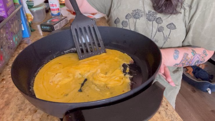 Scrambling eggs in a skillet with a spatula for the carnivore diet